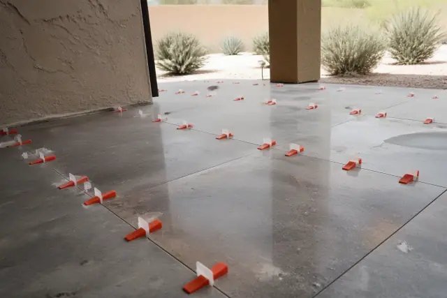 Granite tile installation with leveling clips and wedges on a construction site in Phoenix, AZ.
