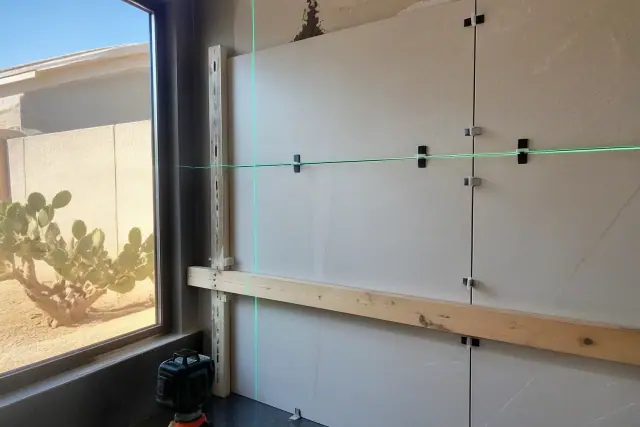 Laser level beam projected over a large format tile backsplash installation in a Phoenix, AZ home.