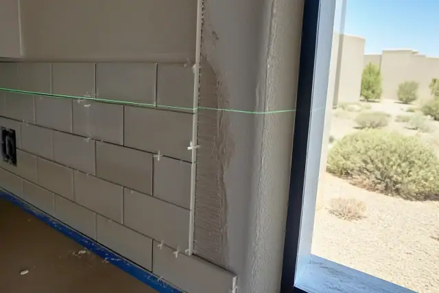 Laser level beam on a subway tile backsplash installation in a home in Goodyear, AZ.