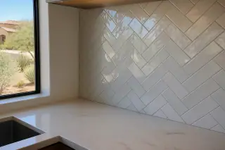 Finished stone tile kitchen backsplash with grout joints in a sun-drenched Phoenix, AZ home.
