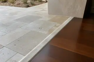 Finished tile floor meeting a wood floor transition strip in a sunlit Phoenix, AZ home.