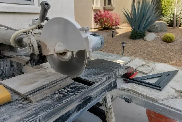 Diamond-blade saw and porcelain tile scraps on a workbench at a Phoenix, AZ residential jobsite.