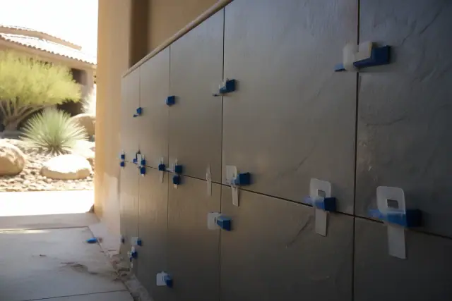 Slate tile shower installation with leveling clips and wedges on a jobsite in Phoenix, AZ.