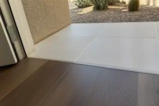 Close-up of a flush tile and wood floor transition strip in a Phoenix, AZ home.