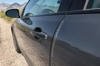 Clean car door frame with adhesive residue after a lockout service on a gravel shoulder in Phoenix, AZ.