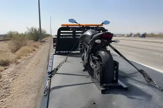 Motorcycle secured with ratchet straps and wheel chocks on a flatbed tow truck in Phoenix, AZ.