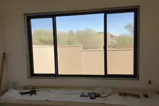 Finished aluminum window installed in a stucco home with tools on a drop cloth in Phoenix, AZ.