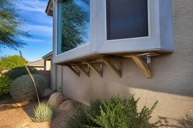 Reinforced support brackets installed under a bay window on a stucco house in Chandler, AZ.