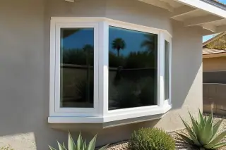 Finished bay and bow window installation on a stucco wall with desert succulents in Phoenix, AZ.