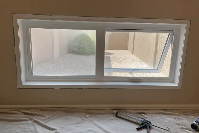 Newly installed casement and awning window frame with sealant in a Tempe, AZ home.