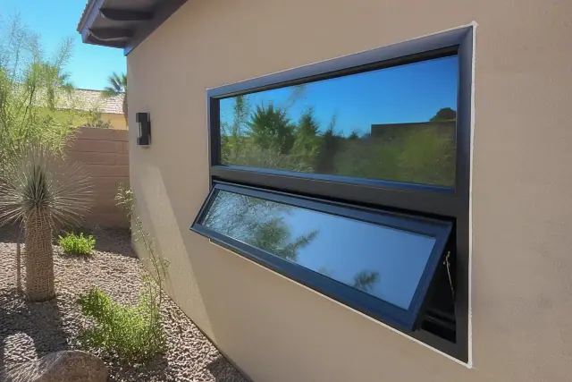 A contractor caulking the frame of a newly installed aluminum casement window at a home in Phoenix, AZ.