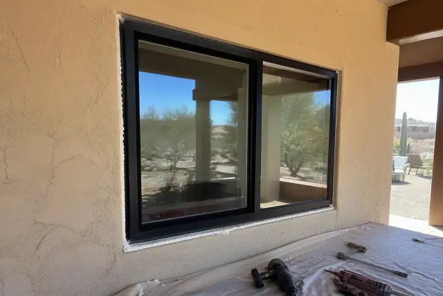 Commercial aluminum window frame installed in a stucco wall at a jobsite in Phoenix, AZ.