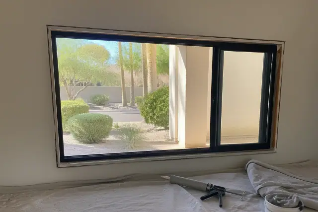 Commercial window installation in Tempe, AZ, featuring a sealed frame on a drop cloth with tools.