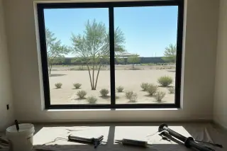 Completed window installation with sealing materials on a drop cloth in a Phoenix, AZ home.