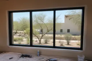 Completed commercial window installation with professional sealant on a drop cloth in a Phoenix, AZ home.