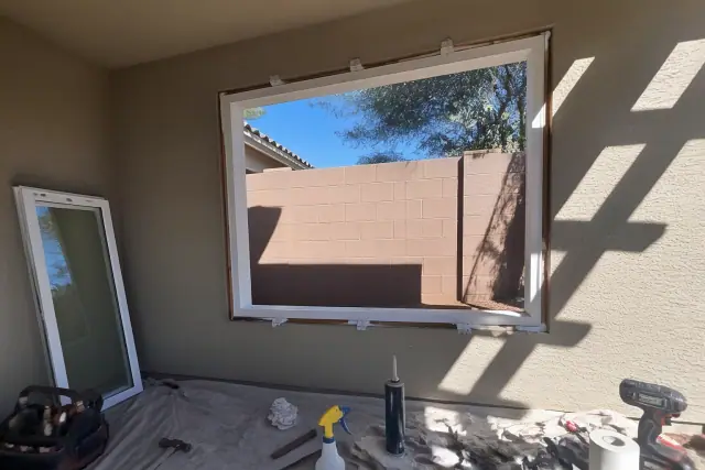 Vinyl window frame installation in progress on a stucco wall at a residential project in Phoenix, AZ.