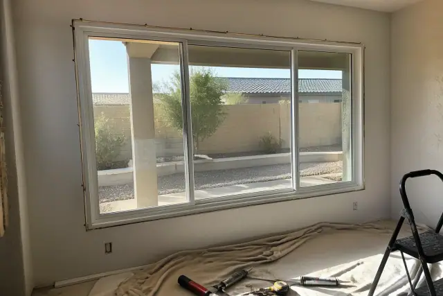 Custom sliding window frame installation in a Phoenix, AZ home with tools on a drop cloth.