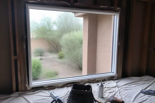 Window frame installation in progress with tools and materials on a drop cloth at a home in Mesa, AZ.