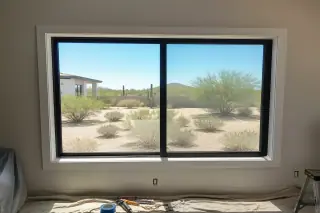 Finished window installation with tools on a drop cloth inside a home in Phoenix, AZ.