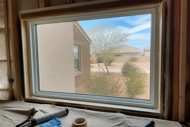 A window frame being installed in a Surprise, AZ home with thermal sealant applied around the edges.
