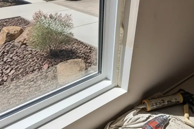 New energy-efficient window installation with sealant and foam in a Goodyear, AZ residential home.