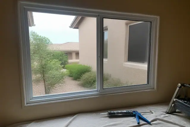 Energy-efficient window frame installation with fresh sealant in a Peoria, AZ residential home.