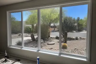 Newly installed energy-efficient windows in a home in Phoenix, AZ, overlooking a xeriscaped desert yard.