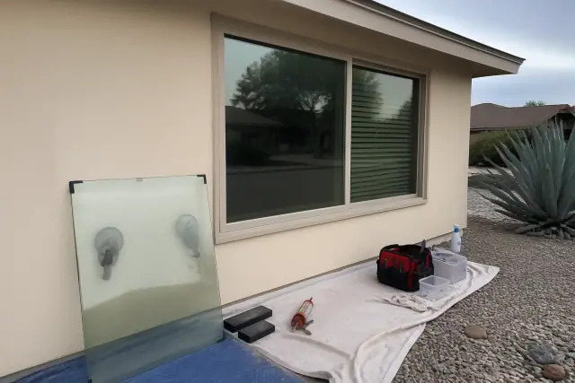 New double-pane window replacement with removed foggy glass and tools on a drop cloth at a home in Phoenix, AZ.
