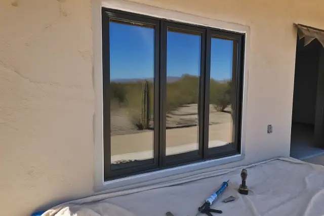 A new commercial window frame installed in a stucco wall at a construction site in Phoenix, AZ.