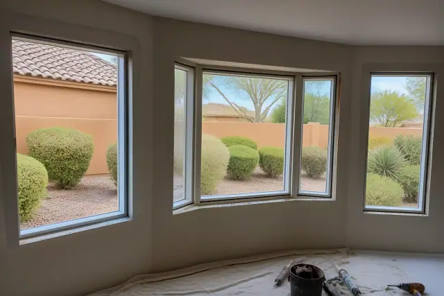 Window frame installation at a job site in Phoenix, AZ, showing tools and materials on a drop cloth.