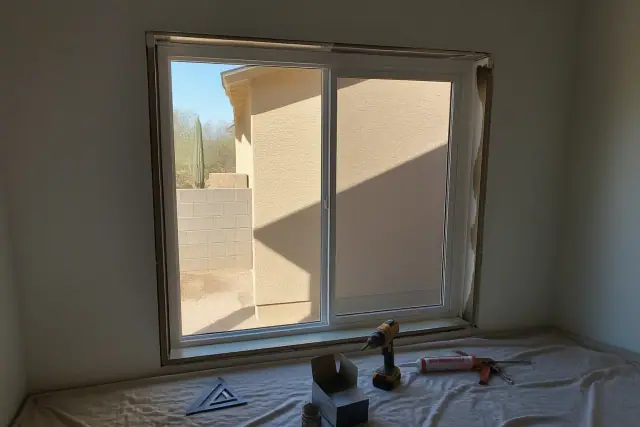Single-slide window frame installation with tools on a drop cloth at a jobsite in Phoenix, AZ.