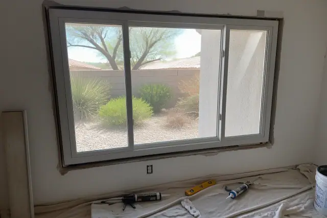 A window frame installation with tools and sealing materials at a job site in Phoenix, AZ.