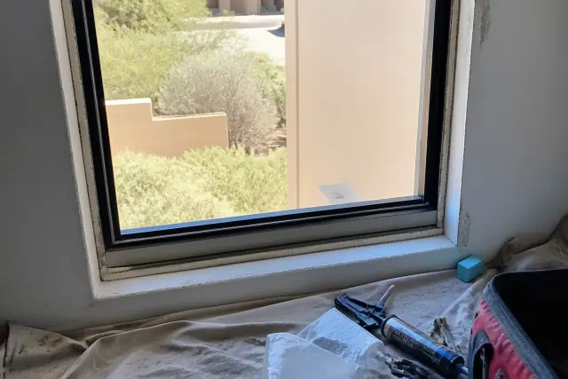Sliding window frame installation with sealant and tools in a home in Peoria, AZ.