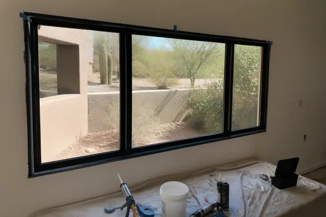 Thermal-break aluminum window frame installation in a Phoenix, AZ residential home under construction.