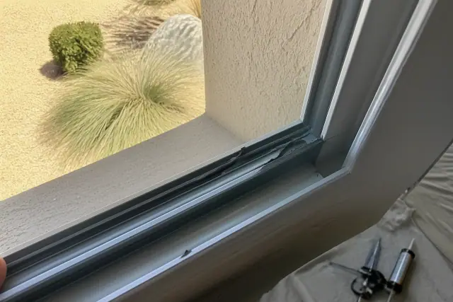 Torn weatherstripping at a window sash edge on a home in Phoenix, AZ.