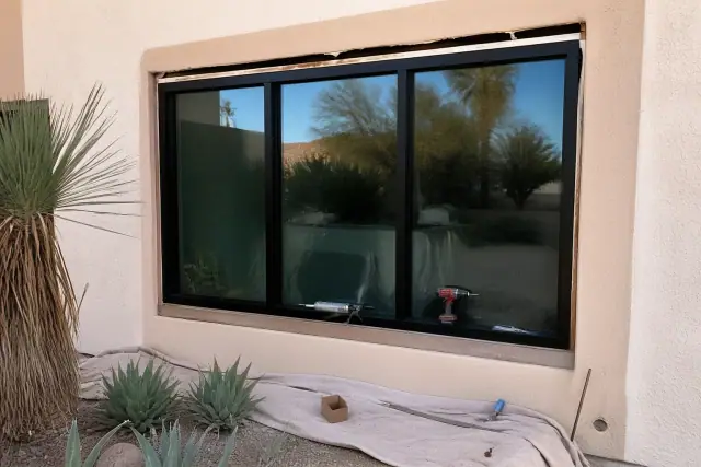 Vinyl window frame installation in progress on a stucco wall at a jobsite in Scottsdale, AZ.