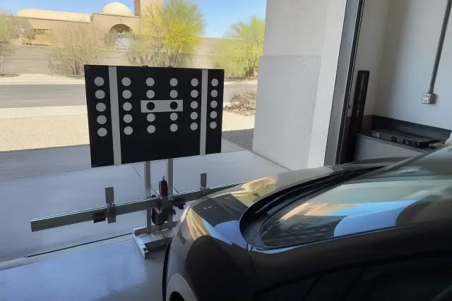 Digital ADAS calibration target stand in front of a vehicle at an auto shop in Avondale, AZ.