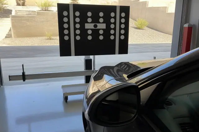 ADAS calibration process with a digital target stand positioned in front of a vehicle in a service bay in Peoria, AZ.