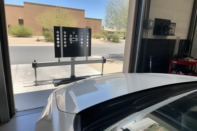 ADAS calibration target stand in front of a vehicle at a service bay in Phoenix, AZ.