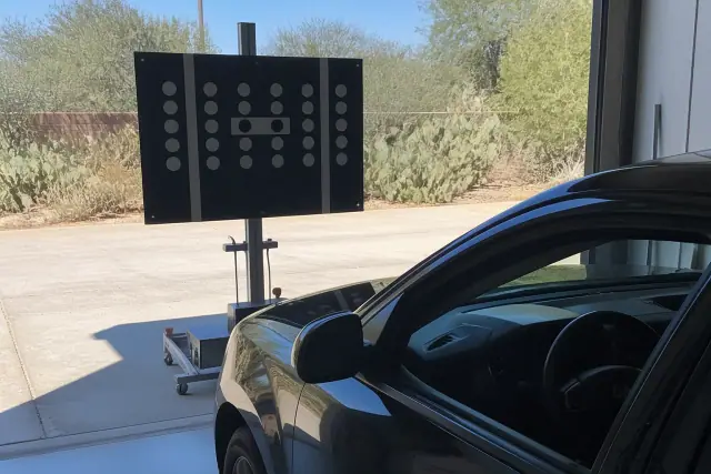 Digital ADAS calibration target set up in front of a vehicle at a shop in Paradise Valley, AZ.