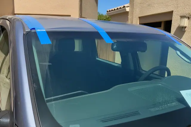 Newly installed windshield with professional retention tape on a vehicle exterior in Mesa, AZ.
