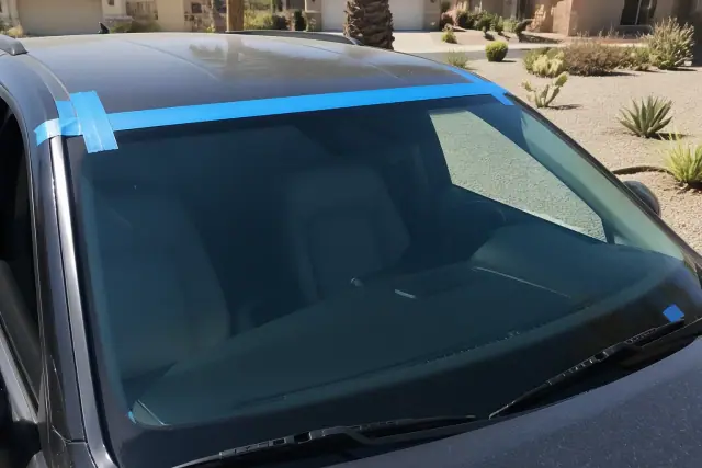 Newly installed windshield secured with retention tape on a vehicle in Tempe, AZ.