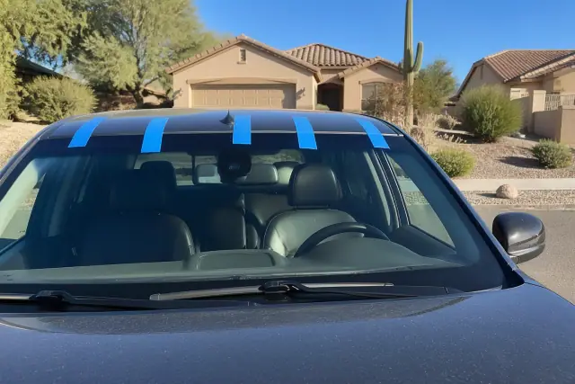 Newly installed car windshield with retention tape in a desert landscape in Chandler, AZ.