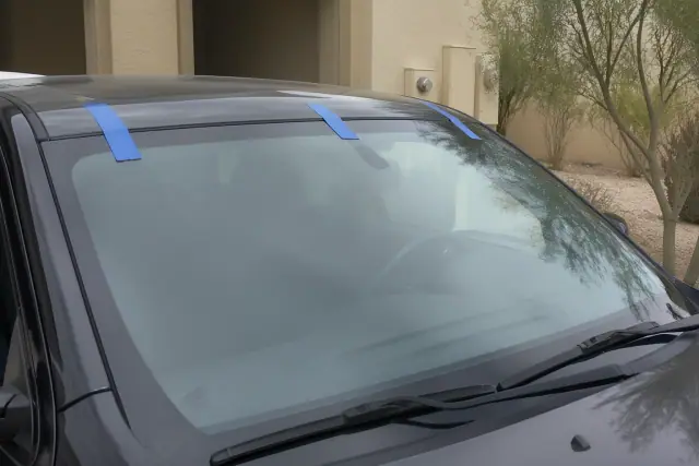 Newly installed car windshield with retention tape at a job site in Avondale, AZ.