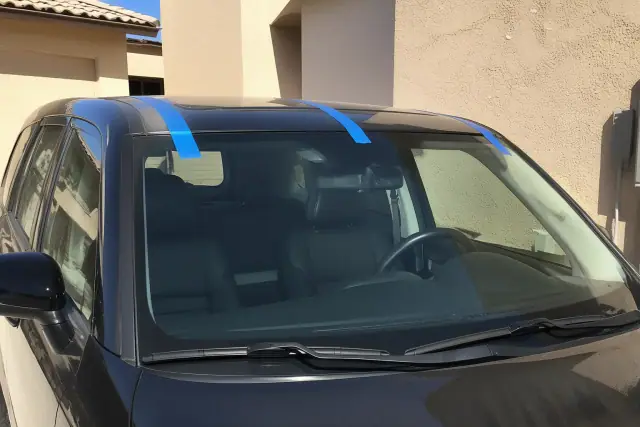 A newly installed car windshield with retention tape on a vehicle in Peoria, AZ.