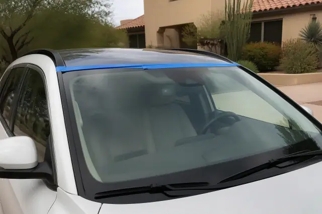 Newly installed car windshield with retention tape parked in a residential driveway in Paradise Valley, AZ.