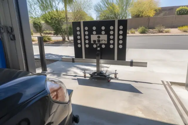 Digital calibration target stand aligned with a vehicle during an ADAS service in Phoenix, AZ.