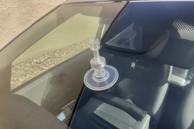 Resin injector tool repairing a crack near an ADAS camera on a vehicle windshield in Phoenix, AZ.