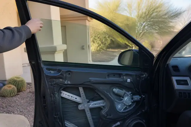 New car window being installed in a vehicle door with interior panel removed in Phoenix, AZ.