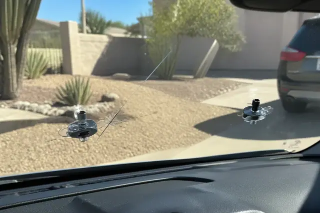 Resin injector tool repairing a windshield star break in Phoenix, AZ, comparing crack visibility to clear sightlines.